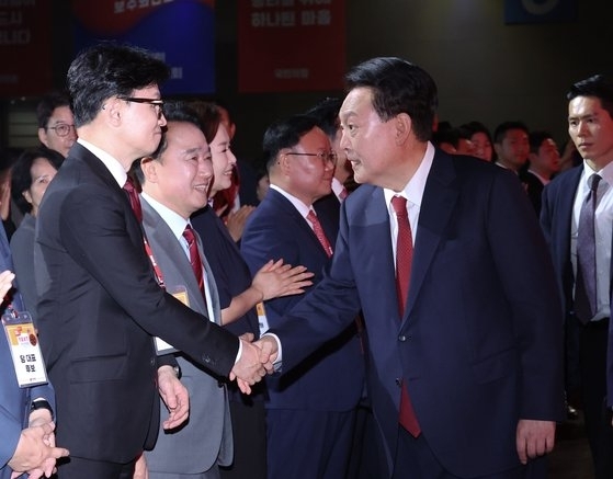 <em>윤석열 대통령이 23일 경기 고양시 일산 킨텍스에서 열린 국민의힘 제4차 전당대회에 입장하며 한동훈 당대표 후보자와 인사하고 있다.뉴시스</em>